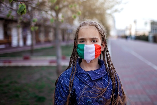 Meisje die het ademhalingsmasker medische masker dragen in de nationale kleuren van Italië