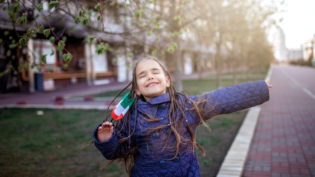 Meisje die het ademhalingsmasker medische masker dragen in de nationale kleuren van Italië