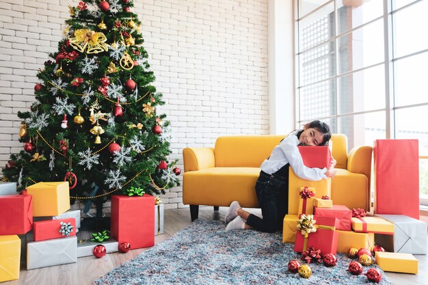 Meisje die Kerstboom in woonkamer verfraaien.