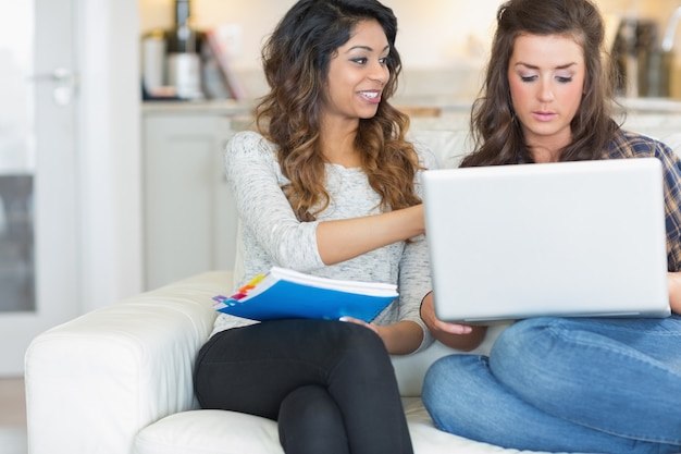 Meisje die op iets aan vriend op laptop wijzen