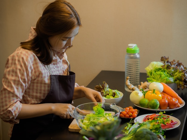 Meisje die schone voedsel en salade in het keukenconcept maken