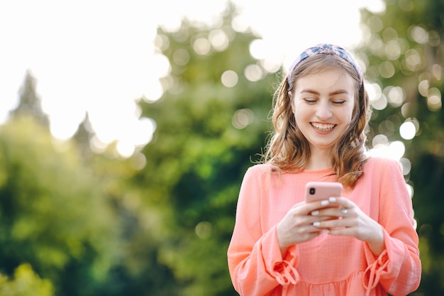 Meisje die slimme telefoon met behulp van bij openlucht en groene aard