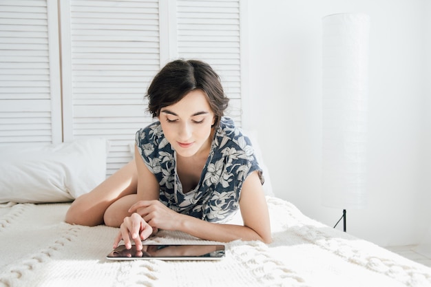 Meisje die tablet in bed bekijken