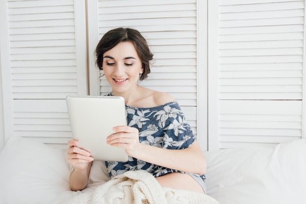 Meisje die tablet in bed bekijken