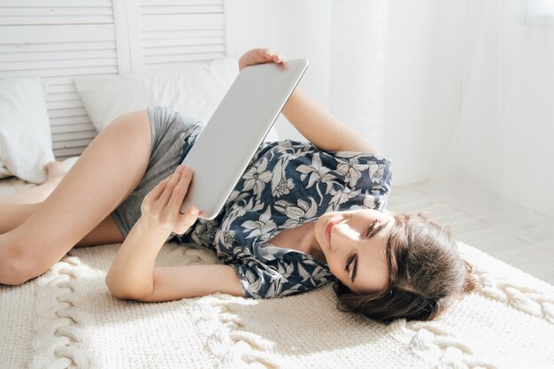 Meisje die tablet in bed bekijken