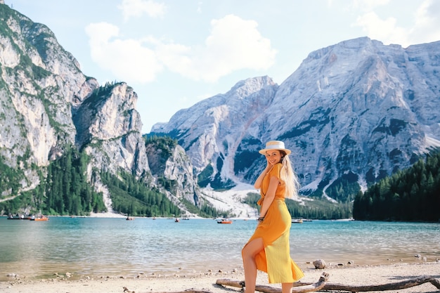 Meisje die zich voordeed op de oever van het schilderachtige bergmeer in de Alpen. uitzicht op Lago di Braies in Dolomieten, Italië, Europa.