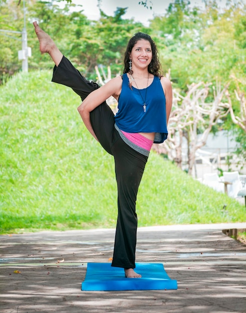 Meisje doet yoga Paradijsvogel een meisje doet yoga buitenshuis Een vrouw doet balansyoga persoon doet yoga Svarga Dvijasana