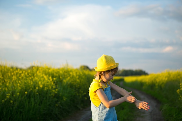 Meisje doodt muggen op haar handen en voeten. Kind slaat zichzelf op het lichaam, krabt aan beten, bescherming tegen insectenbeten, afweermiddel veilig voor kinderen. Buitenrecreatie, tegen allergieën