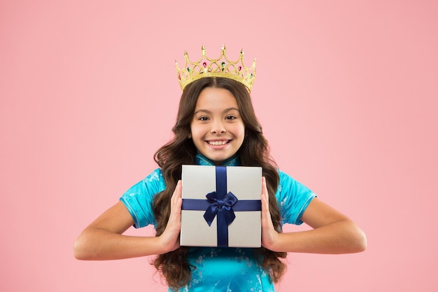 Meisje draagt kroon Prinses omgangsvormen Award concept Geschenkdoos Winnaar schoonheidswedstrijd Internationale schoonheidswedstrijd Kinderkleding gouden kroon symbool van glorie Schoonheidswedstrijd Kleine prinses