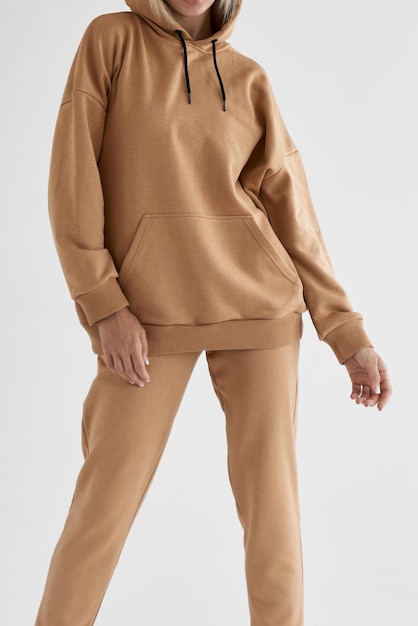 Meisje draagt lichtbruine hoodie en broek geïsoleerde foto van vrouwen die nude kleur fleece textiel outfit dragen