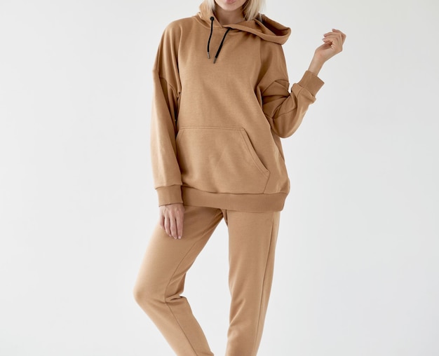 Meisje draagt lichtbruine hoodie en broek geïsoleerde foto van vrouwen die nude kleur fleece textiel outfit dragen