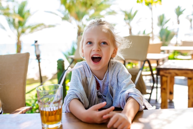 Meisje drinkt fruitcocktail tegen de zee