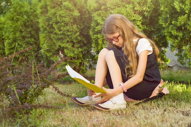 Foto meisje een basisschoolstudent die schoolnotitieboekje lezen