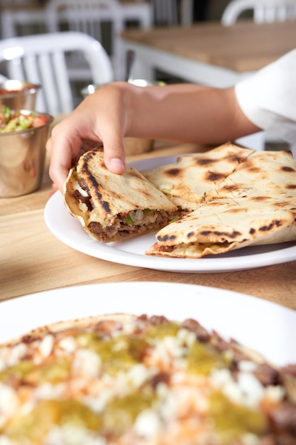 Meisje eet heerlijk typisch Mexicaans eten taco's sopes pastor enz