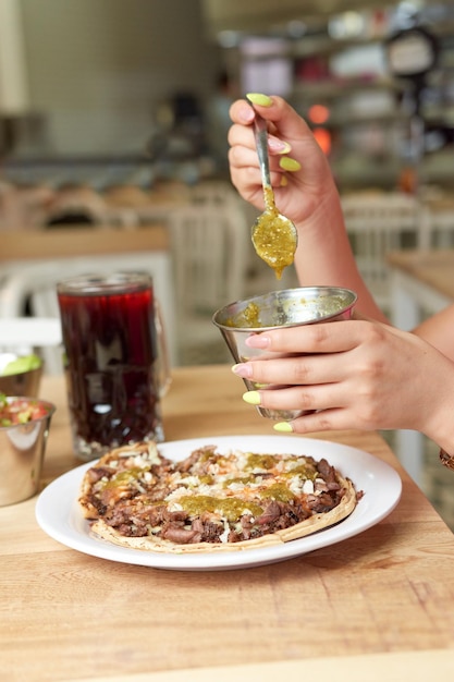 Meisje eet heerlijk typisch Mexicaans eten taco's sopes pastor enz