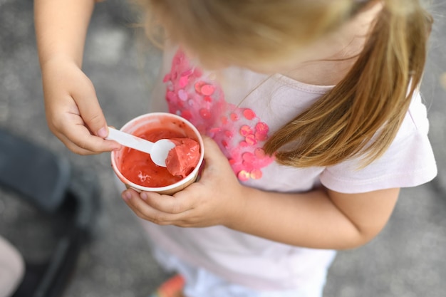 Meisje eet roze ijs. uitzicht van boven