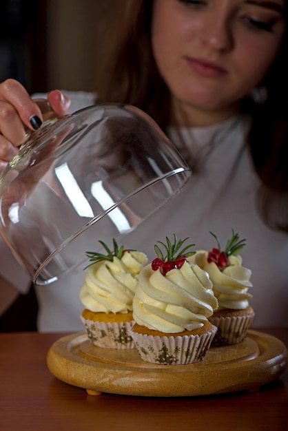 Meisje en cupcakes Mooie vrouw met zoete taarten op donkere achtergrond