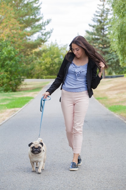 meisje en haar trouwe viervoeter pug voor een wandeling.