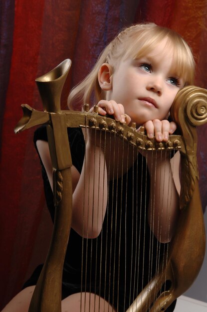 Foto meisje en harp muziekinstrument.