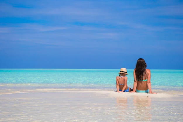 Meisje en jonge moeder tijdens strandvakantie