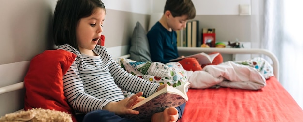 Meisje en jongen die een boek lezen