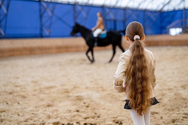 Meisje en paard in de rijzaal.