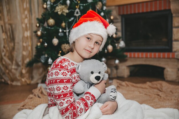 Meisje en speelgoed bij de kerstboom in de woonkamer