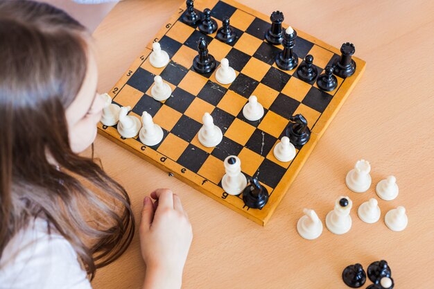 Meisje en vader spelen thuis een spelletje, schaken, puzzelen voor hersenontwikkeling, mentale intelligentie