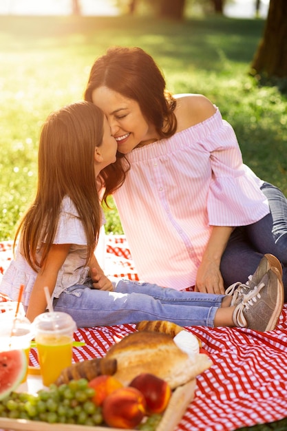 Meisje en vrouw bij picknick in het park neus aan neus aanraken