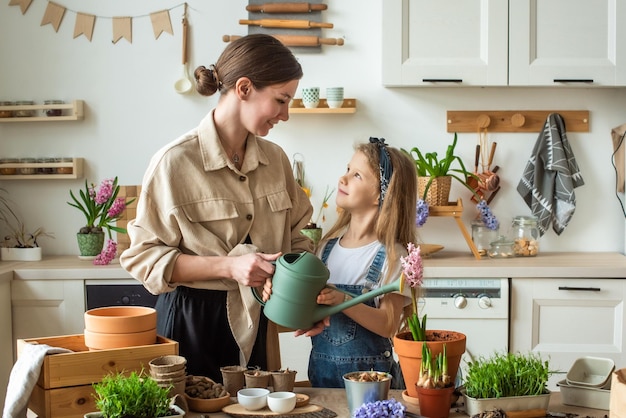 Meisje en vrouw transplanteren bloemen kamerplanten plant en waterhyacinten microgreens samen