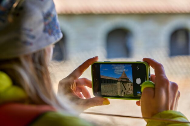 Meisje fotografeert het oriëntatiepunt op een mobiele telefoon. Een foto maken op een smartphone tijdens het reizen. Fort Oreshek