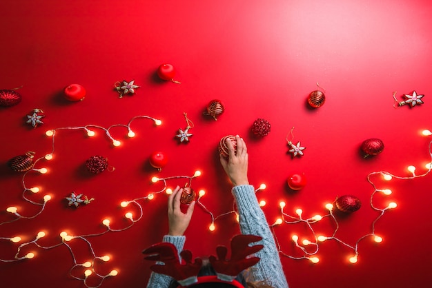 meisje gebruikt de hand om de bal rode decoraties op een rood te houden