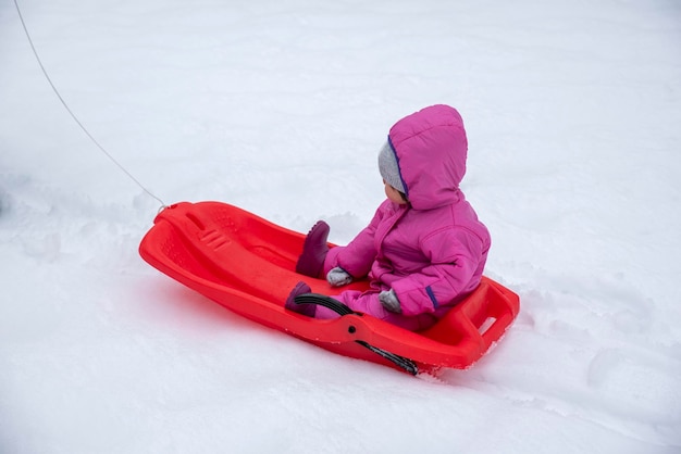 Meisje geniet van een sledetocht buiten in de sneeuw