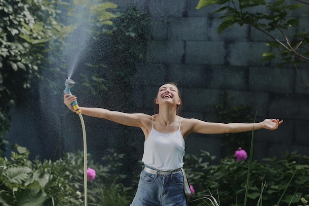 Meisje geniet van water in de hitte van de zomer in de tuin