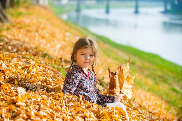 Meisje het spelen met de herfstbladeren in het park