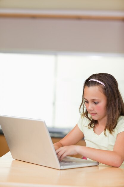 Meisje het typen op laptop in de keuken