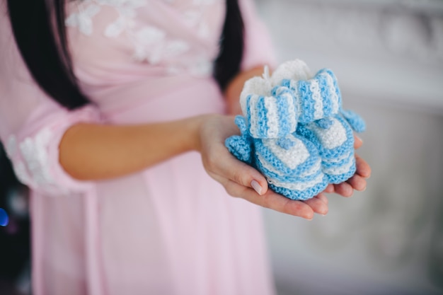 Meisje houdt baby blauwe slofjes in de rivieren