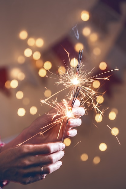 Foto meisje houdt bengaalse lichten vast - fijne kerstdagen en fijne feestdagen