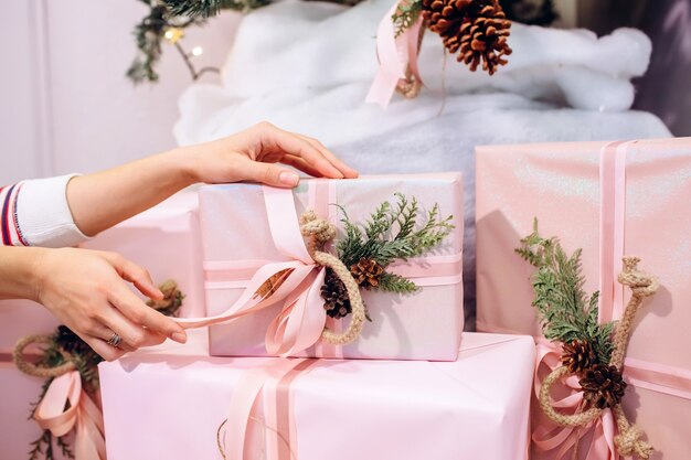 Meisje houdt een geschenk, kerstboom, roze doos met een geschenk