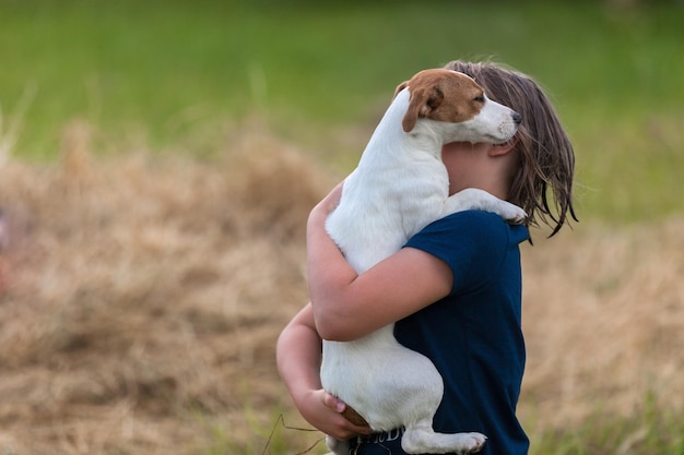 Meisje houdt Jack Russell Terriër in haar armen soft focus