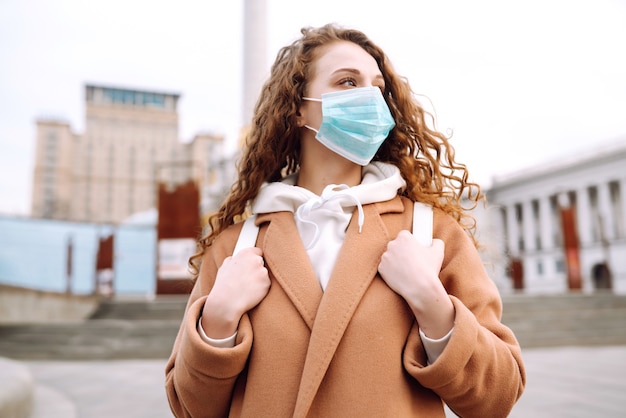 Meisje in beschermend steriel medisch masker op haar gezicht op straat