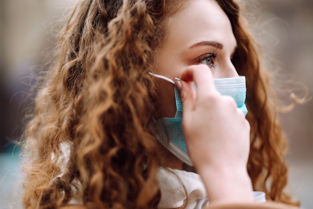 Meisje in beschermend steriel medisch masker op haar gezicht op straat