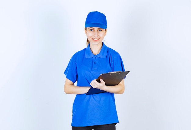 Meisje in blauw uniform met een zwarte rapportmap.