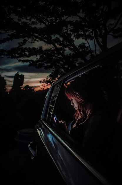 Foto meisje in de auto op een zonsondergang rit