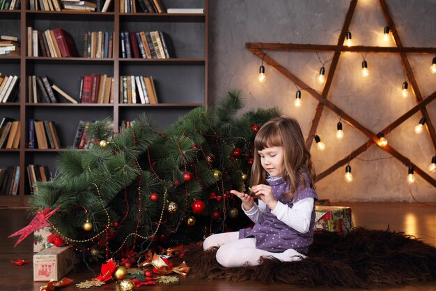 Meisje in de buurt van een omgevallen kerstboom