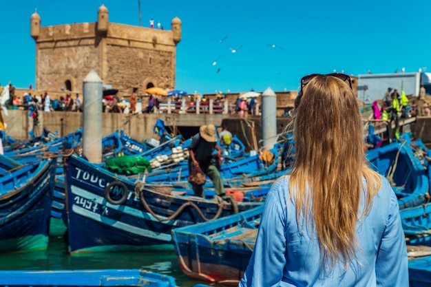 Meisje in de haven van Essaouira. beroemde blauwe boten.