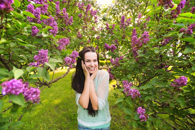 Meisje in een bloeiende tuin. Vrouw gelukkig in het park