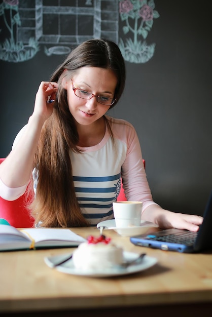 Meisje in een café voor een kopje koffie met het notitieboekje