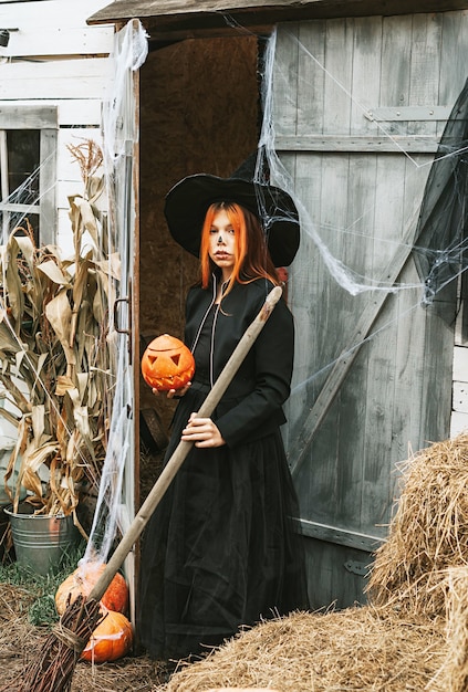 Foto meisje in een heksenkostuum met een bezem op een halloween-feest
