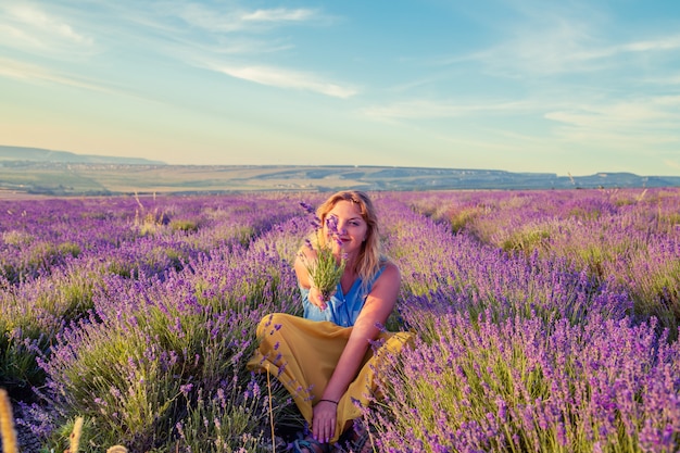 Meisje in een lavendel veld bij zonsondergang. Zonnige zomeravond op de Krim.